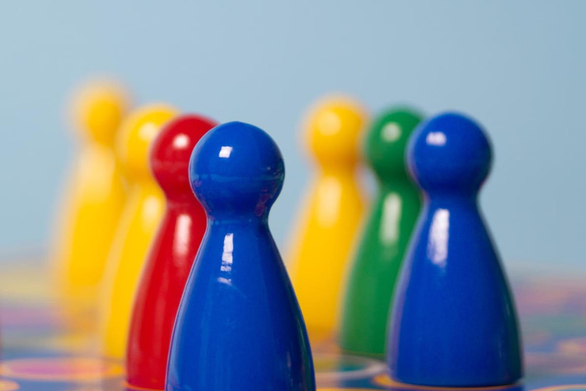 Fichas de juego de mesa de colores alineadas sobre un tablero
